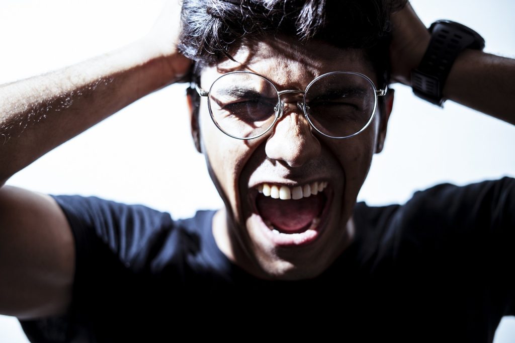 Rostro de una persona gritando con expresión de angustia. Imagen simbólica de sufrimiento emocional.